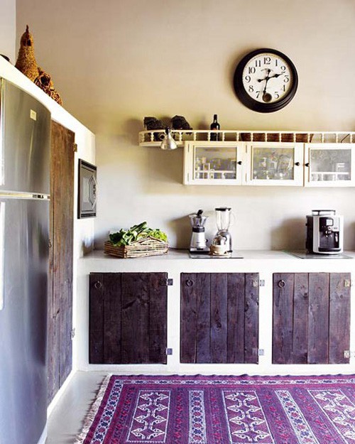 a stained kitchen with white framing and a colorful printed rug feels cozy and very boho at the same time