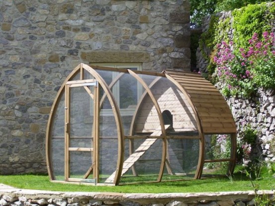 a boat-shaped catio of wood and mesh, with green lawn, a house and a ladder is a simple and natural space to stay