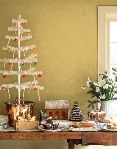 a Scandi Christmas sweets table decorated with a white Christmas tree with colorful ornaments and a white bloom arrangement