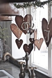 an evergreen branch with heart gingerbread cookies hanging down from it is a cozy Nordic feel in the space
