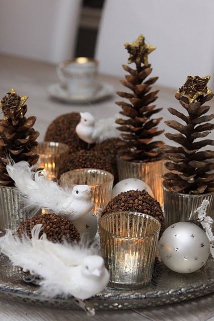 a Christmas centerpiece of a silver tray, natural ornaments, metallic ornaments and pinecone Christmas trees