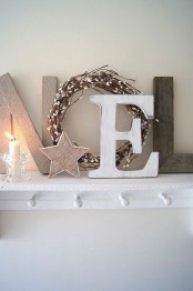 wood and plywood NOEL letters, stars, a wreath and a candle in a glass candleholder for a Nordic feel in the space