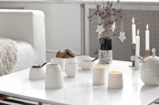 floral branches with white star Christmas ornaments and candles for a cozy Nordic feel at the table