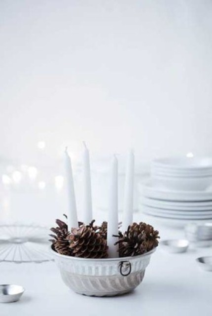 a bowl with pinecones and candles is a stylish decoration or centerpiece for Christmas