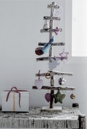 a Christmas tree made of driftwood and with colorful Christmas ornaments is very natural