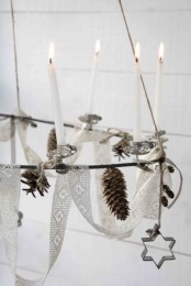 a Nordic chandelier with lace ribbons, pinecones, candles and cookie cutters is a very Nordic and cool idea to go for