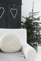a Christmas tree decorated with lights, white ornaments in a basket looks Scandinavian-like