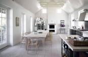 a neutral Nordic kitchen with metal cabinets, a whitewashed dining set and pendant lamps