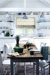 a white Nordic kitchen with shiplap walls, open shelving, vintage cabinets, a rustic table and whitewashed chairs