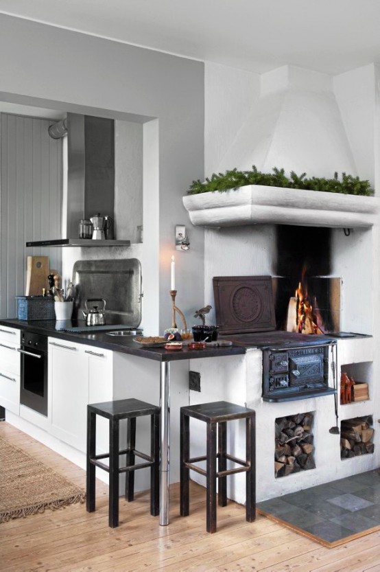 a contemporary meets vintage Scandinavian kitchen with a stove, white cabinets with a black countertop, touches of metal and black stools