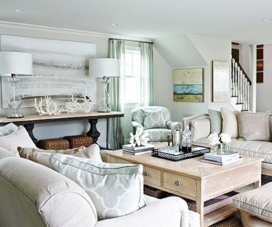 an off-white and aqua beach living room with a vintage coffee table, a large artwork and some corals and driftwood for decor