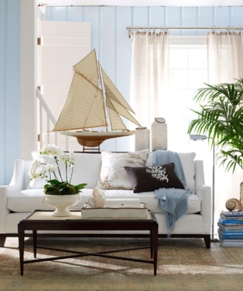 a beachy living room in light blues, with neutral furniture and printed pillows