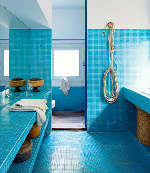 a super bright blue contemporary bathroom with touches of rope, baskets and neutra towels
