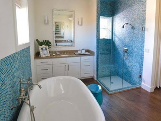 a blue and white sea-inspired bathroom with a white vanity with a wooden countertop, an oval bathtub