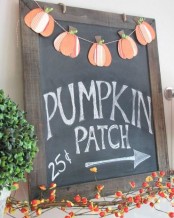 a simple and cute orange pumpkin paper banner is a lovely and colorful idea for a rustic space in the fall or at Thanksgiving