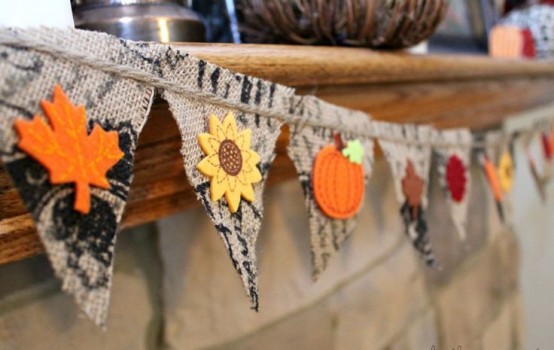 a burlap banner with bright fabric leaves, sunflowers and pumpkins is a cool decor idea for the fall or Thanksgiving