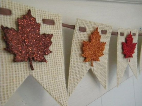 a white burlap banner with glitter fall leaves attached is a cool and bright idea for a rustic space, it can give a cozy feel to it