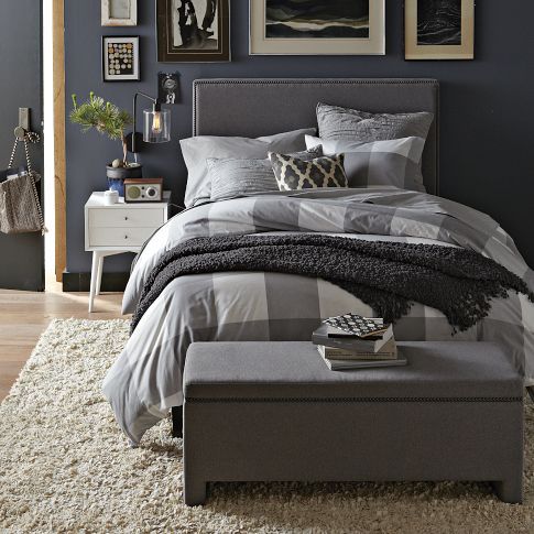 a light grey upholstered bed and a matching chest for storage will make your mid-century modern bedroom welcoming