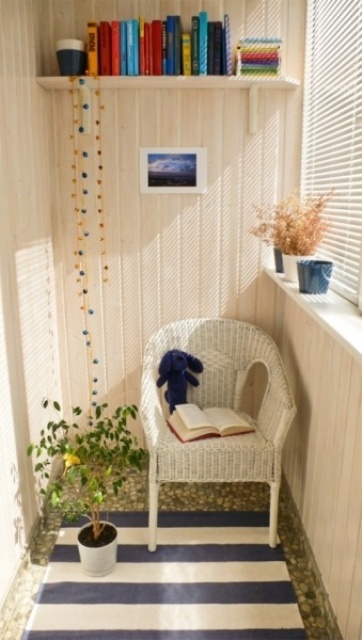 a small Scandinavian balcony with a striped rug, a woven chair, a bookshelf, a potted plant and colorful books