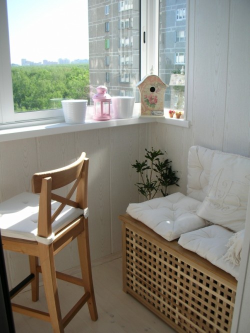 a small and cozy balcony with a white seat on IKEA Hol table, a small stool and some decor is a lovely space