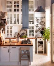 a small white kitchen with double ceilings, the height is used for additional storage cabinets here, which is a veyr smart idea