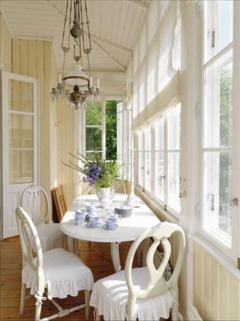 a vintage-inspired sunroom nook with a tea space with sophisticated furniture and vintage lamps