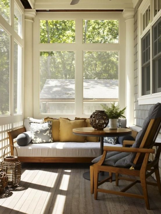 a tiny mid-century modern sunroom with some comfortable furniture,wicker lamps and potted greenery