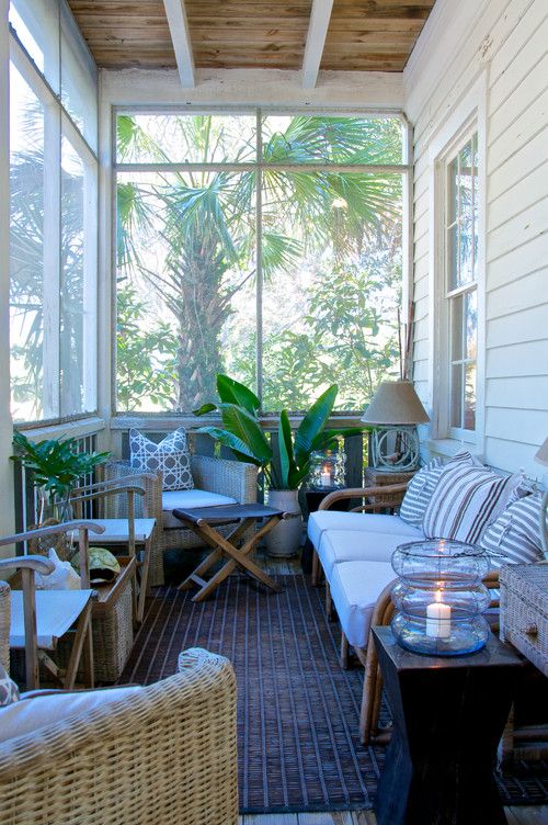 a tropical-inspired small sunroom with wooden furniture, wicker chairs, potted greenery and lamps