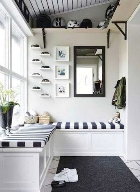 a monochromatic space with a striped built-in bench, a rug and some shelves for storage
