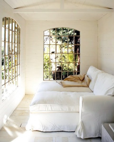 a sophisticated small sunroom with comfortable lounge chairs and French windows that brign elegance