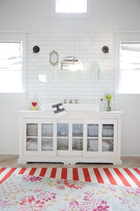 a white vintage sideboard as a bathroom vanity, with glass doors and baskets for storage is a lovely idea for a modern space, too