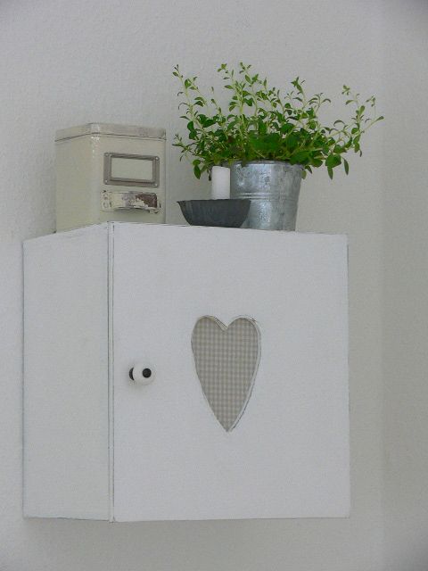 a small whitewashed cabient with a cutout heart is a pretty solution for a Scandinavian or shabby chic space and it looks amazingly cute