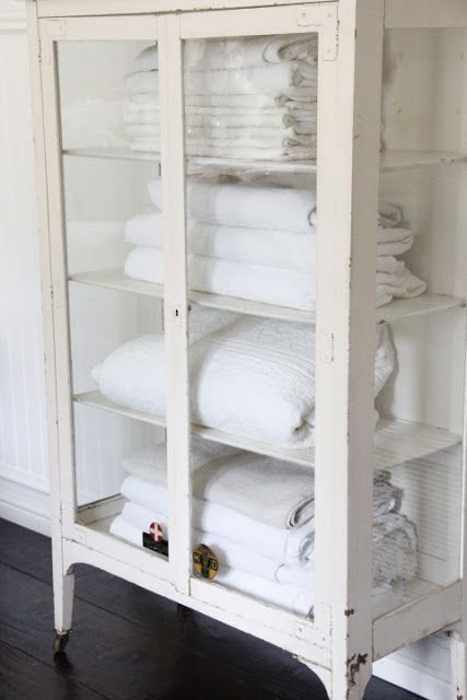 a whitewashed glass wardrobe with lots of shelves is a great solution for a bathroom with a slight vintage feel, and it will display anything else you want