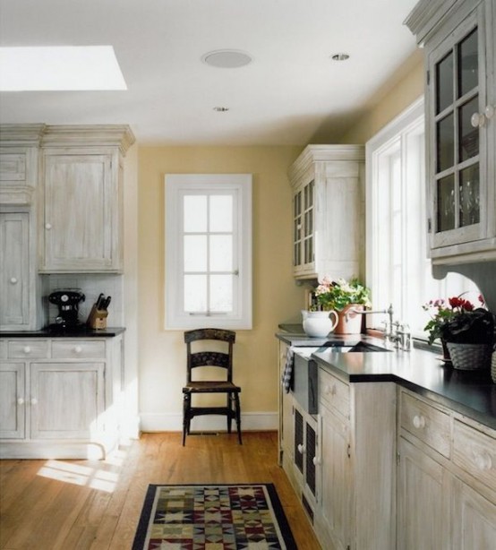 a vintage planked whitewashed kitchen with black countertops and a matching whitewashed backsplash is a gorgeous idea with a contrast