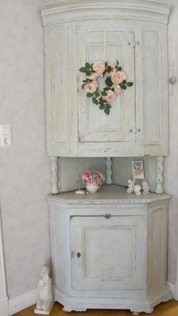 a vintage whitewashed corner cabinet of two parts connected with each other and with pink blooms is a lovely idea