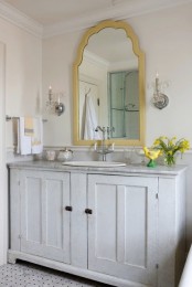 a shabby chic whitewashed bathroom vanity with a stone countertop and a vintage faucet is a very chic and stylish idea to rock