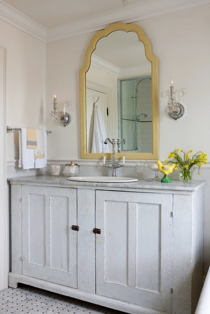 a shabby chic whitewashed bathroom vanity with a stone countertop and a vintage faucet is a very chic and stylish idea to rock