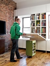 a desk, kitchen island or dining table can be folded to cover the shelves or unfolded to use it