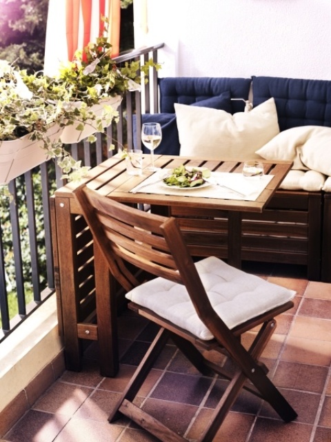 a wooden folding table and chair by IKEA will save space on your small balcony letting you enjoy fresh air at its best