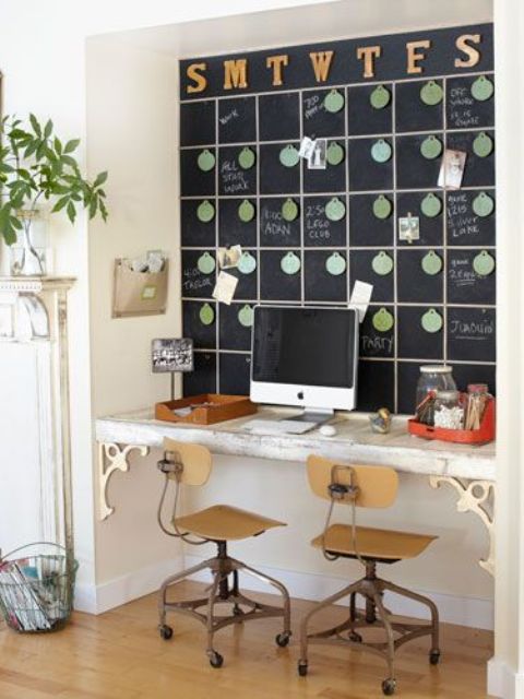 an eclectic working nook with a chalkboard schedule that is used for planning, a built-in vintage desk and industrial chair and potted greenery