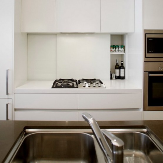 a cooker backsplash of sliding panels is a cool and smart way to hide spices and oil is a smart solution