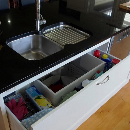 a hidden drawer right under the sinks is a cool idea for a kitchen, this space usually goes neglected