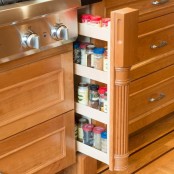 a small and narrow rack for spices hidden in a very narrow compartment between the cabinets