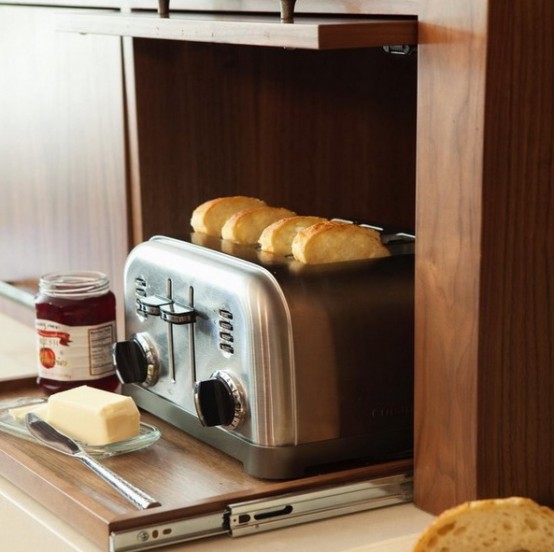 a toaster hidden inside a cabinet and placed on a retractable shelf is a cool idea for any home, hide it and make the space sleek
