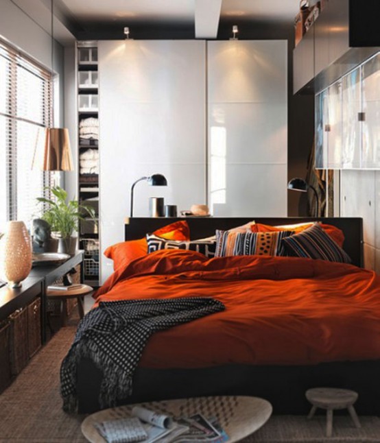 a small yet stylish bedroom with a sleek storage unit, some shelves and a window bench, a black bed and bold bedding