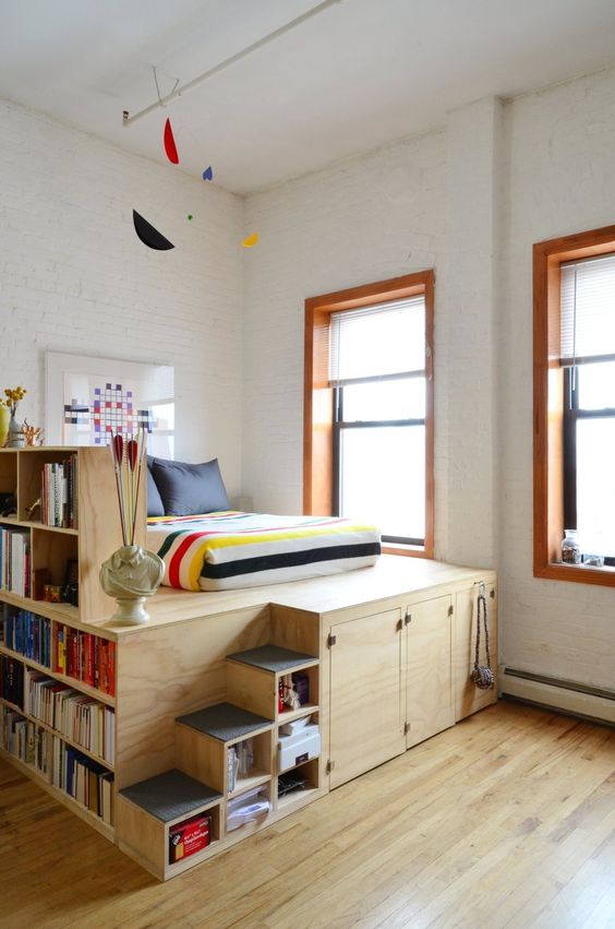 a large platform with open and closed storage compartments, with bookshelves and a bed is a nice solution for any space