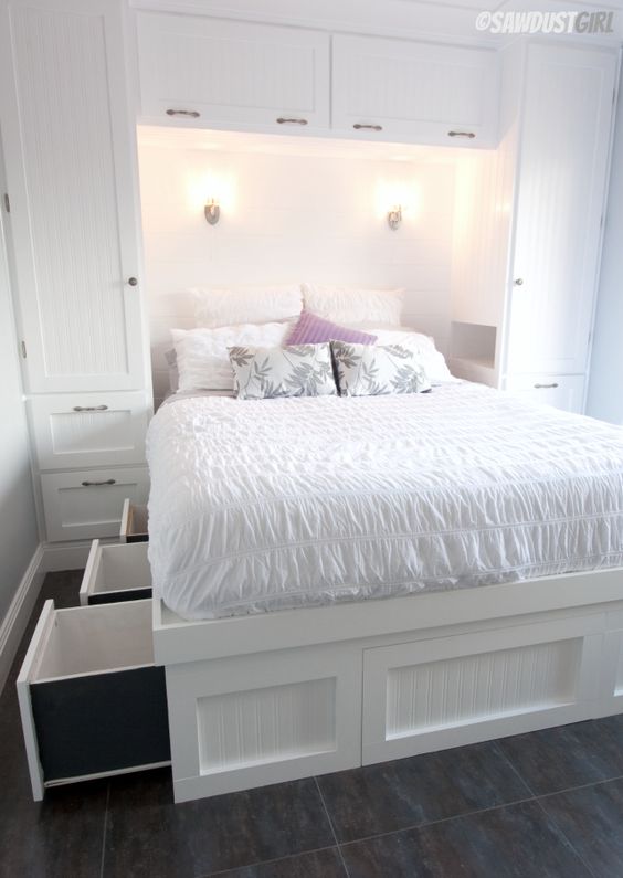 a white built-in bed with storage drawers in the sides of the bed is a cool idea to go for