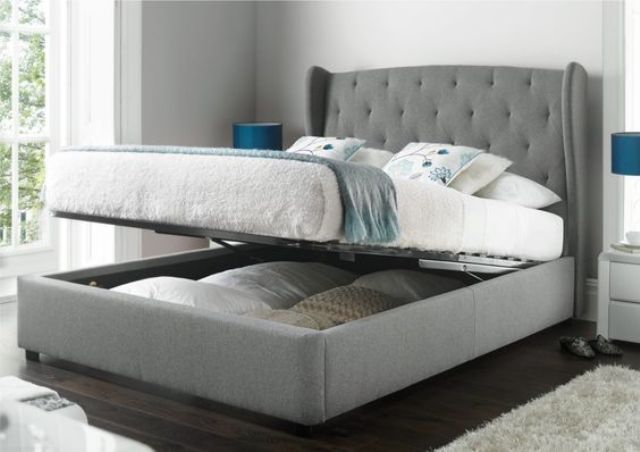 a grey upholstered bed that can be raised to place some things inside it is a cool piece to rock