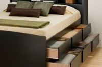 a functional black bed with a storage headboard and two levels of drawers in the sides is a cool solution to rock