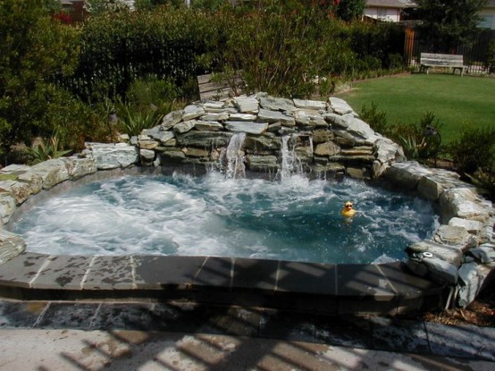 an outdoor jacuzzi with a waterfall clad with stone will be loved by everyone